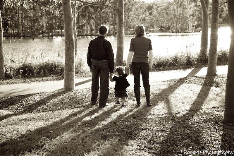 Sepia family of 3 walking hand in hand at the park - family portrait photography sydney